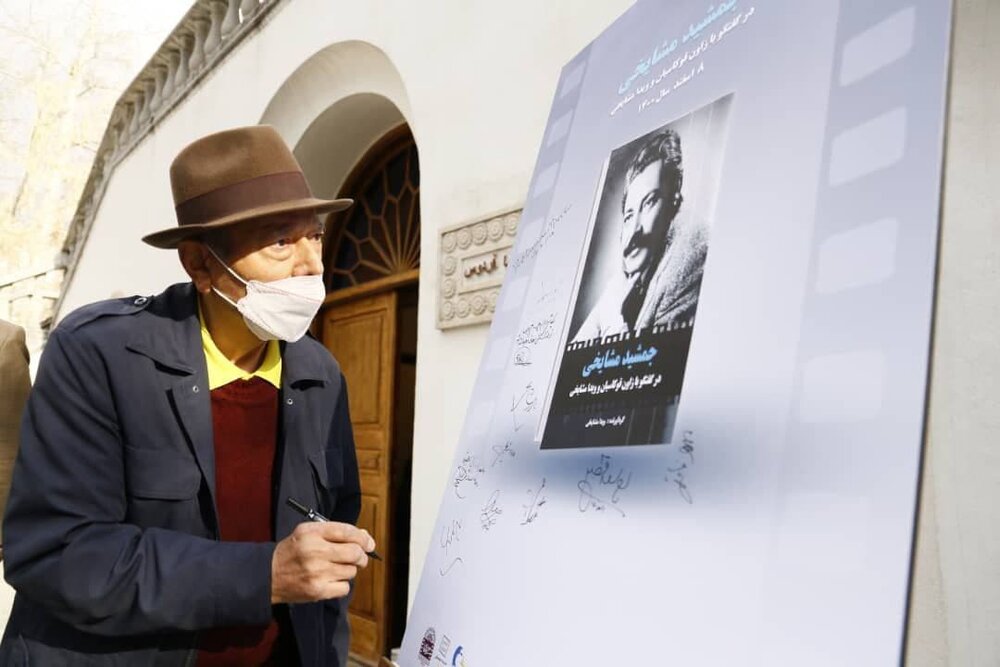علی نصیریان در حال امضای پوستر کتابی درباره جمشید مشایخی/ عکس