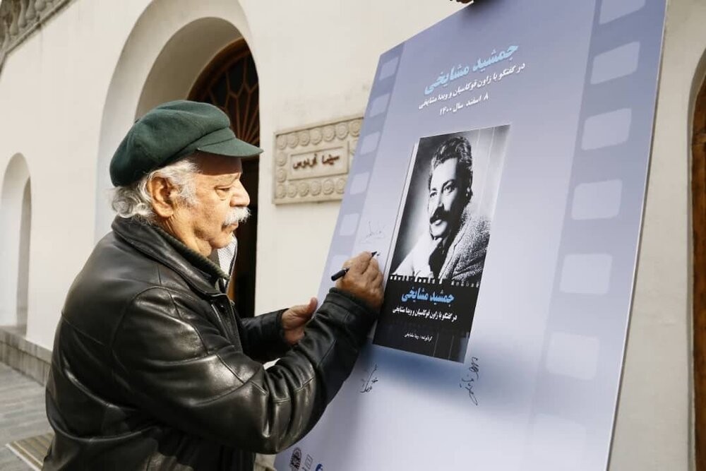 علی نصیریان در حال امضای پوستر کتابی درباره جمشید مشایخی/ عکس